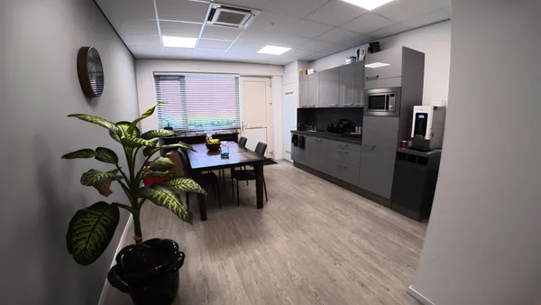 Kantine met houten eettafel en koffiemachine