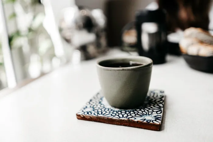 Koffiemok op een keramische onderzetter met patroon