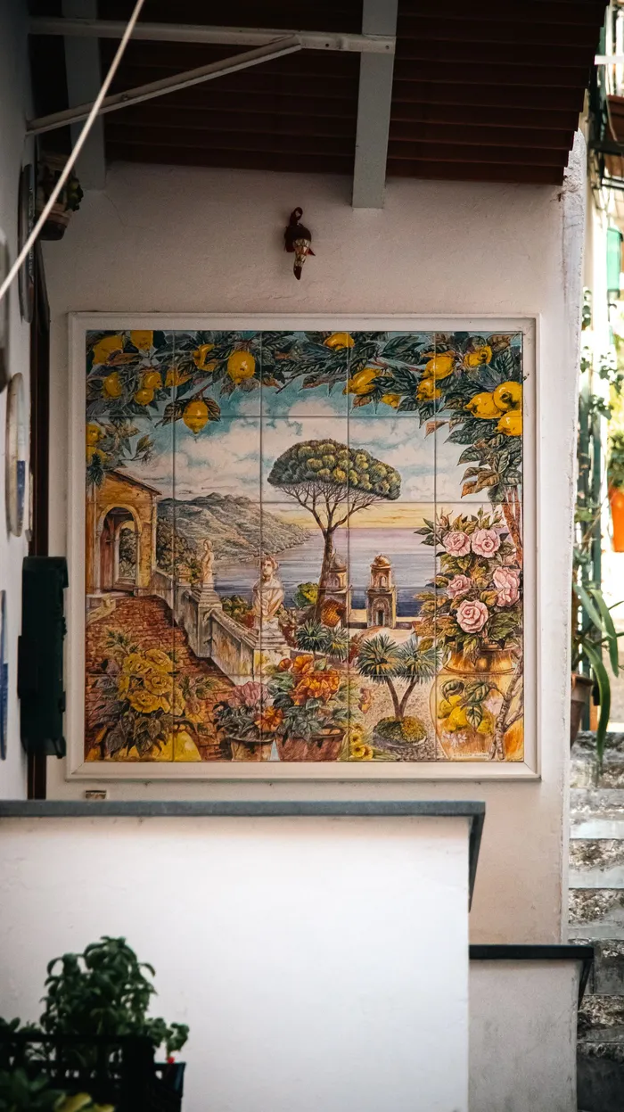 Ingelijst tegeltableau met kustlandschap aan de muur
